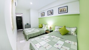 A bedroom with two beds, green bedding, a nightstand with a lamp, and framed pictures on the wall. - Hotel Portal de San Antonio (Cartagena)