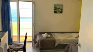 A room with a bed, a chair, a desk, and a painting. - Sissi Mare Apartments (Agios Nikolaos)