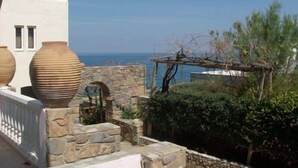 A stone wall with large vases and a pergola overlooking a coastal view. - Sissi Mare Apartments (Agios Nikolaos)