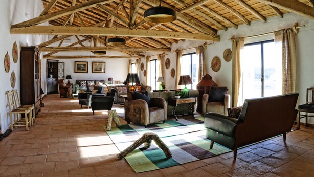 A spacious living room with wooden beams, a checkered floor, and various seating arrangements. - Herdade da Maxuqueira (Gaviao)