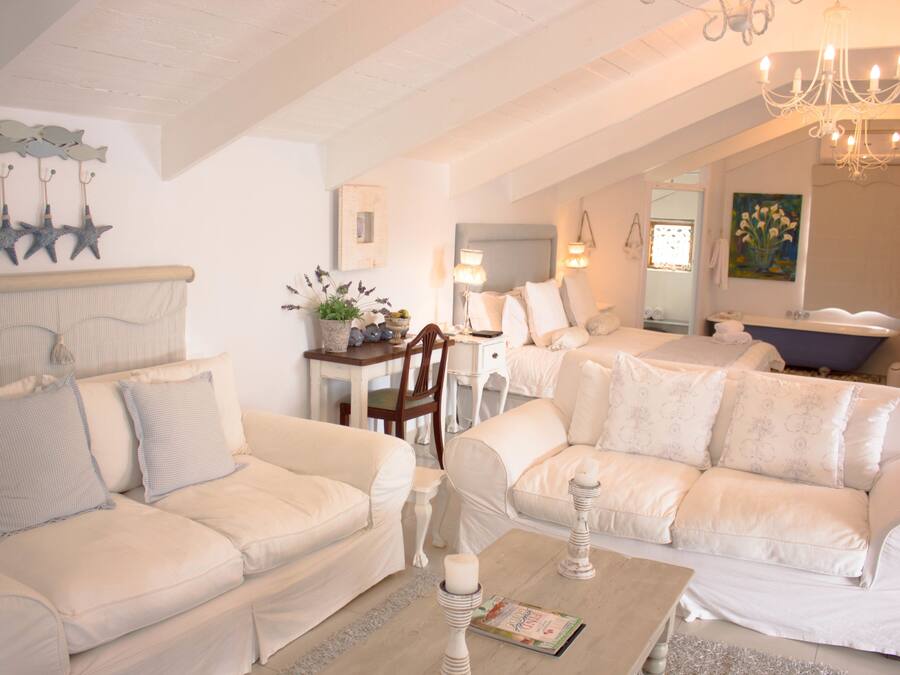 Ein gemütliches Wohnzimmer mit zwei weißen Sofas, einem Holztisch und einer Chandelier.