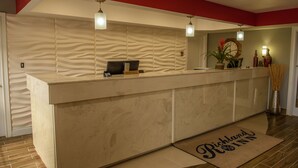 A reception area with a marble counter, a zebra-patterned wall, and a reception desk. - Richland Inn Lawrenceburg (Lawrenceburg)