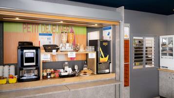 Zona de buffet per a l'esmorzar, amb una màquina de cafè KREA, un dispensador de cafè Vaillant i diferents aliments.