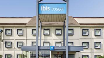Un bâtiment d’hôtel avec une enseigne indiquant « ibis budget ».