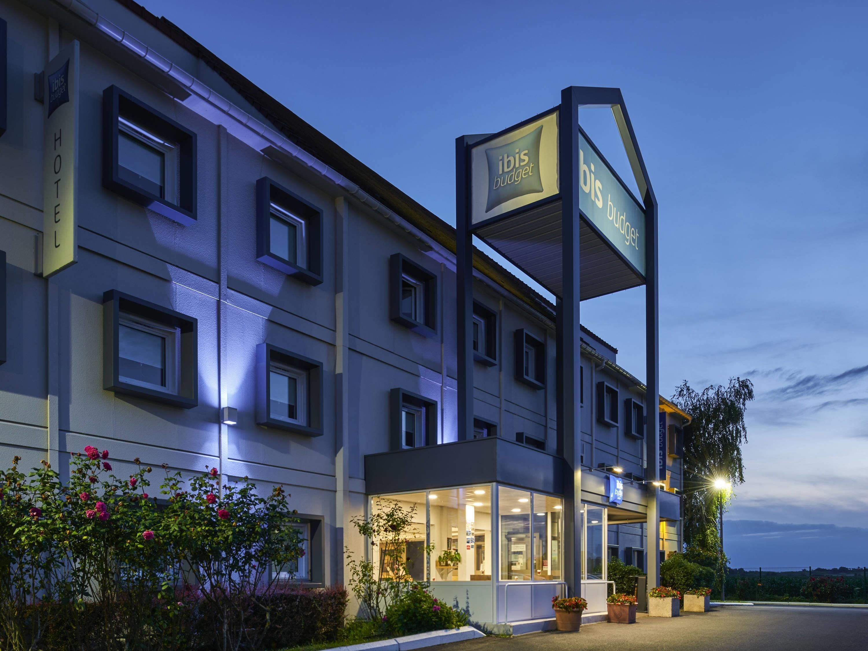 Un hôtel reconnaissable à son panneau « ibis budget » bien visible, à ses nombreuses fenêtres et à son entrée bien éclairée.