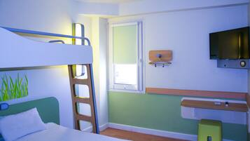 Une chambre avec des lits superposés, un bureau, une télévision et une fenêtre.
