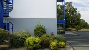 Een modern gebouw met een bord waarop staat: ibis budget hotels.