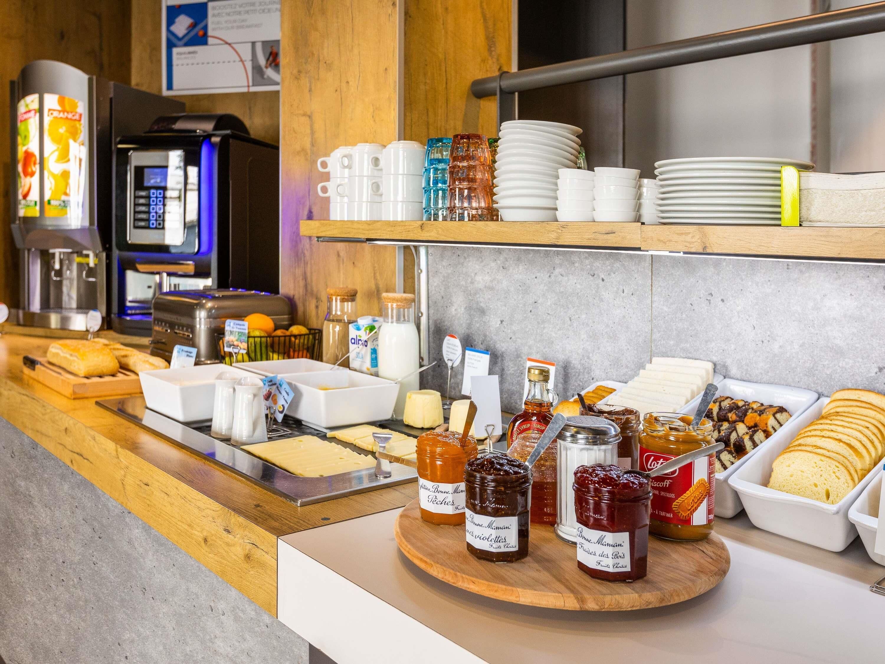 A breakfast buffet with various food items, condiments, and a coffee machine.
