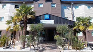 A hotel with a sign reading 'ibis budget hotels' and 'Deauville Saint-Arnaud.' - ibis budget Deauville (Saint-Arnoult)