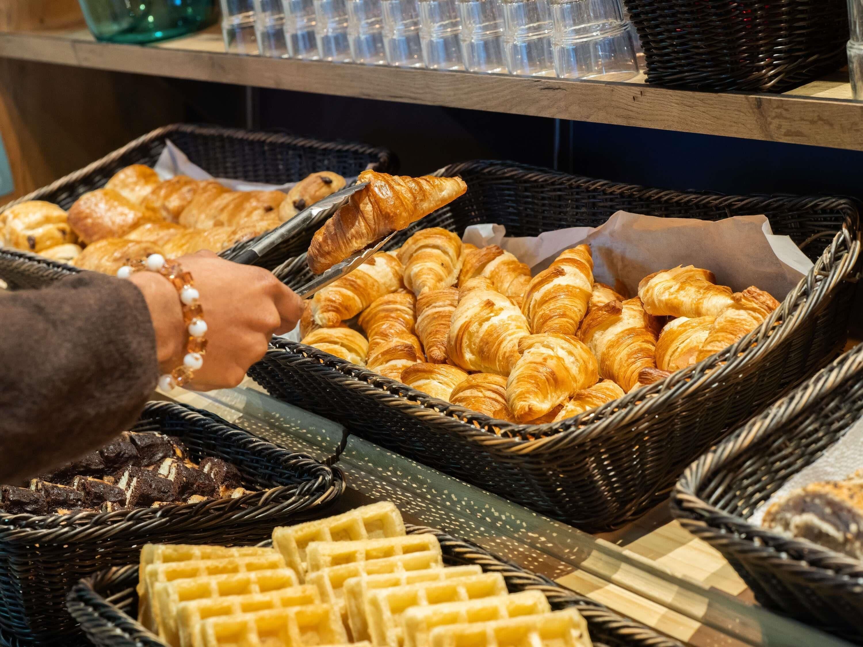 A bakery display with baskets of croissants and waffles.