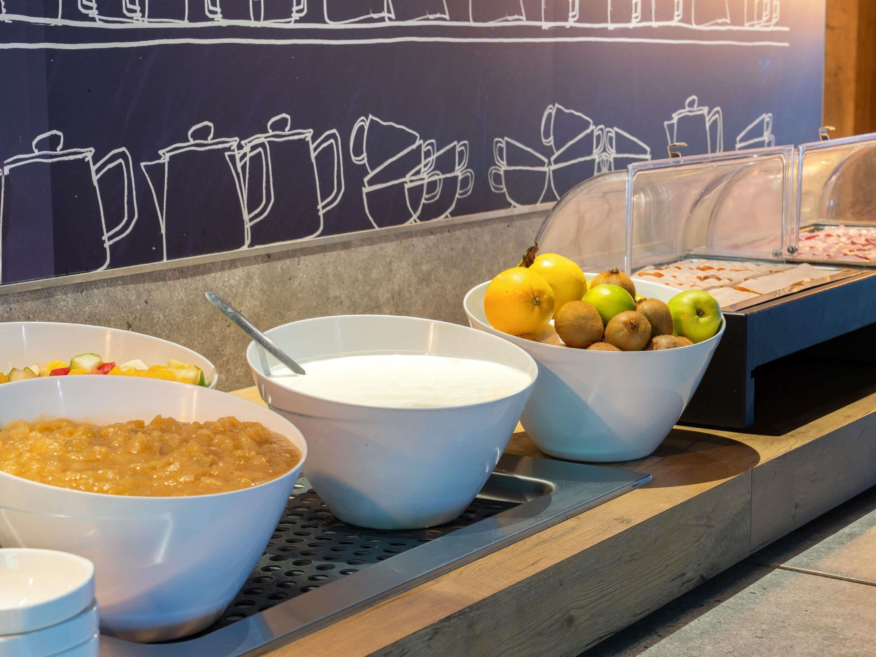 Zona de bufé con fuentes de comida y frutas.