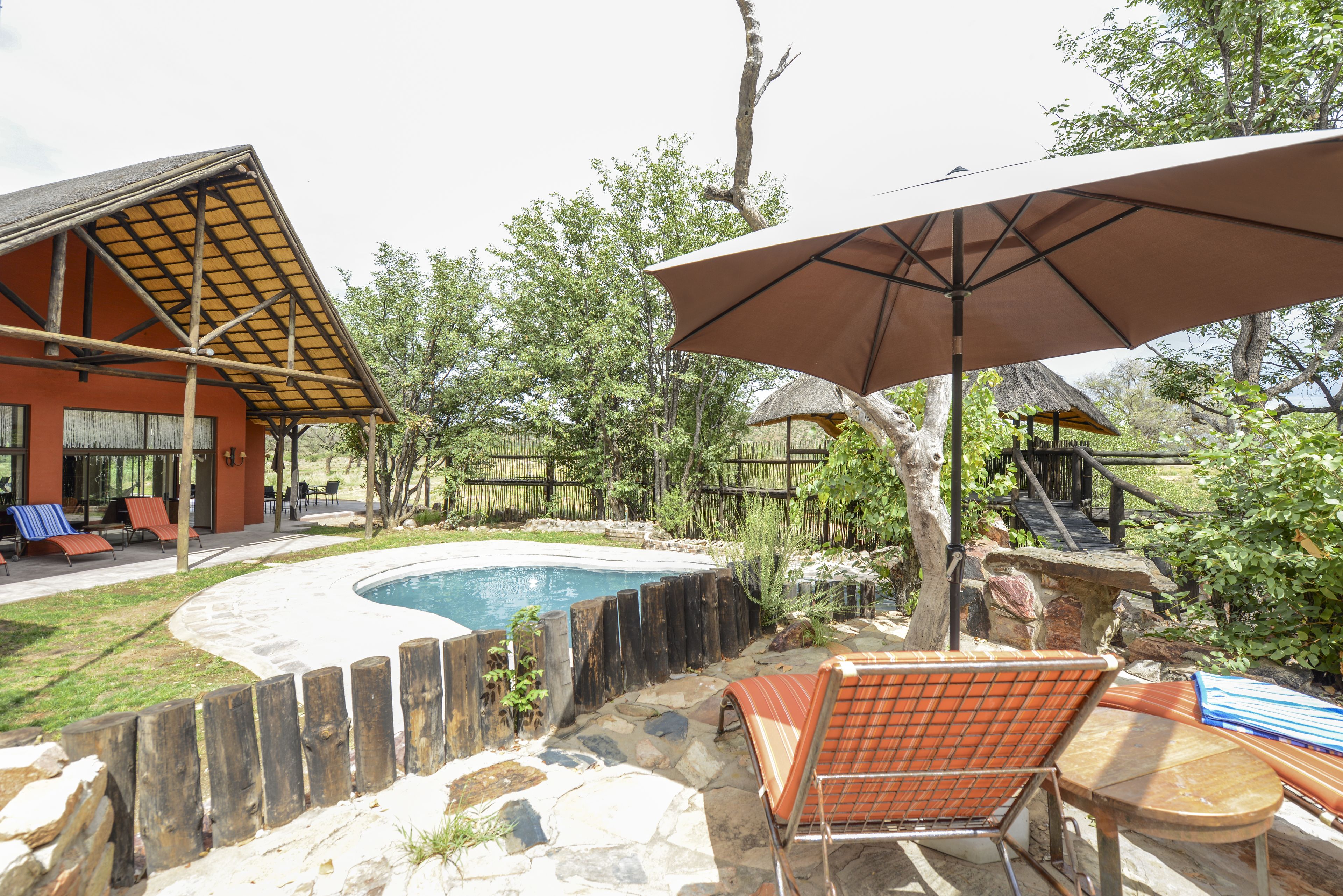 Una piscina al aire libre, sillones reclinables de piscina