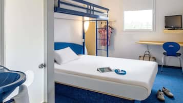 Una cama individual superpuesta con escritorio y silla, televisión y ventana con vistas.