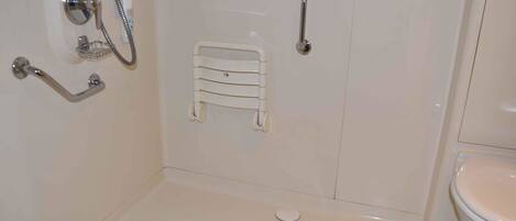 A bathroom with a bathtub, a toilet, a shower, and a towel rack.
