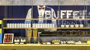 Een buffetopstelling met diverse gerechten en een koffieapparaat.