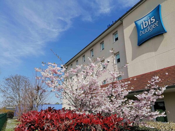 A building with a sign reading "ibis budget" and a clear blue sky. - ibis budget Bergerac (Bergerac)