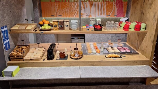 A breakfast buffet with various food items, including pastries, fruits, and beverages. - ibis budget Bergerac (Bergerac)