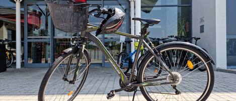 Una bicicleta estacionada frente a un edificio con un letrero que dice 'ibis Hotels'.