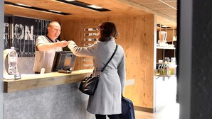 A person at a wooden counter with a digital scale and a bottle of water.