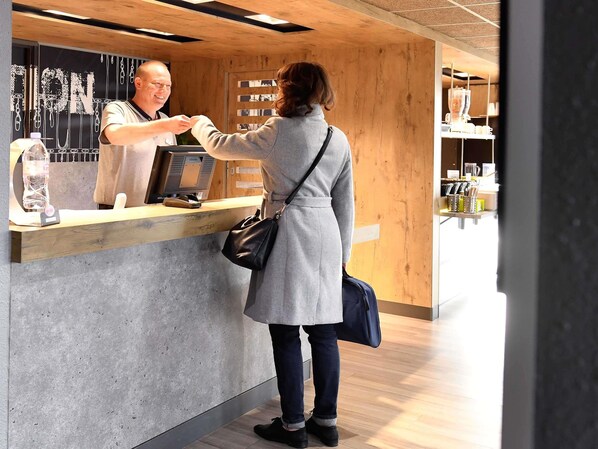 A person at a wooden counter with a digital scale and a bottle of water.