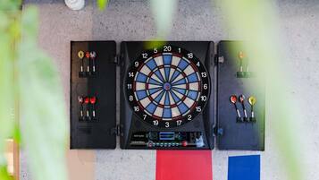 A dartboard with three dartboards aligned horizontally, each with darts and a score chart.