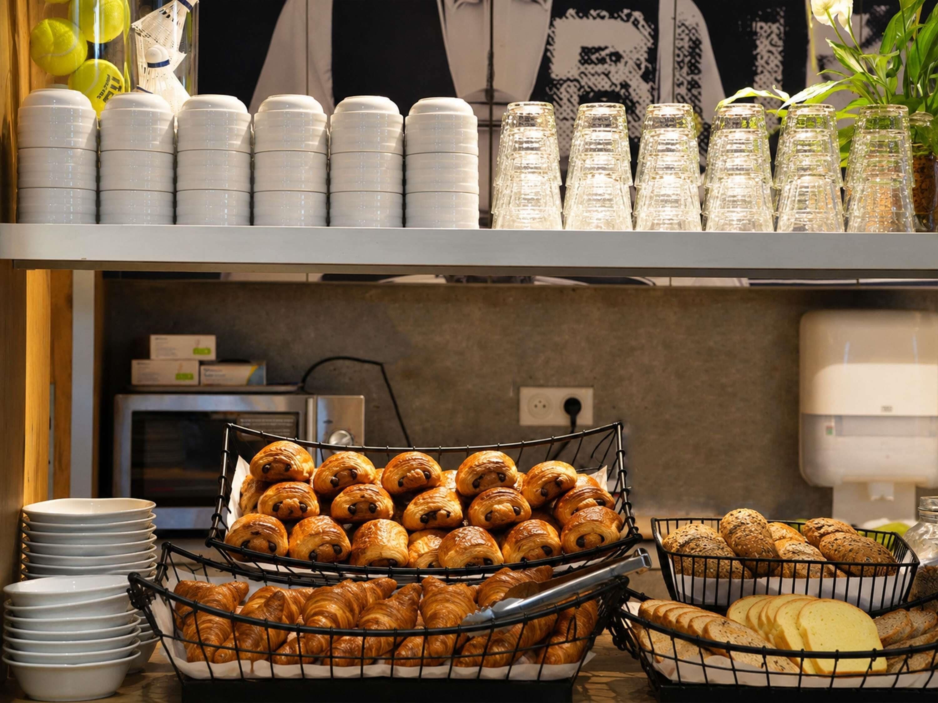 Ein Buffet mit Croissants, Brot und Gläsern.