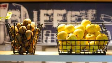 Una encimera de cocina con dos cestas de alambre que contienen fruta.