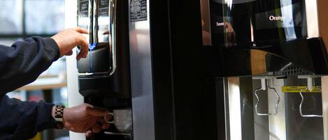 Una máquina de café con pantalla digital y dispensador de agua.