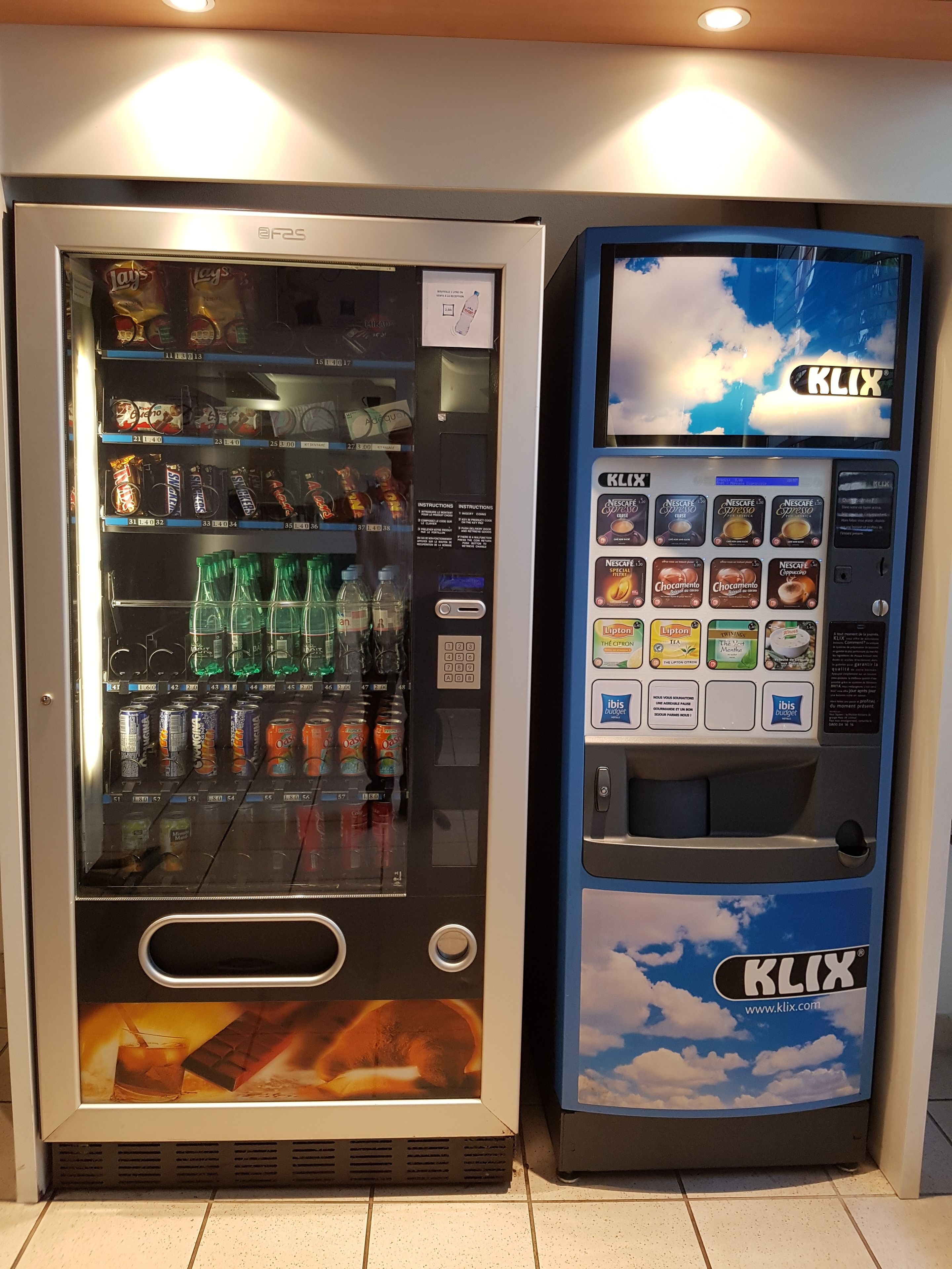 Two beverage vending machines, one with a variety of drinks and the other with coffee options.