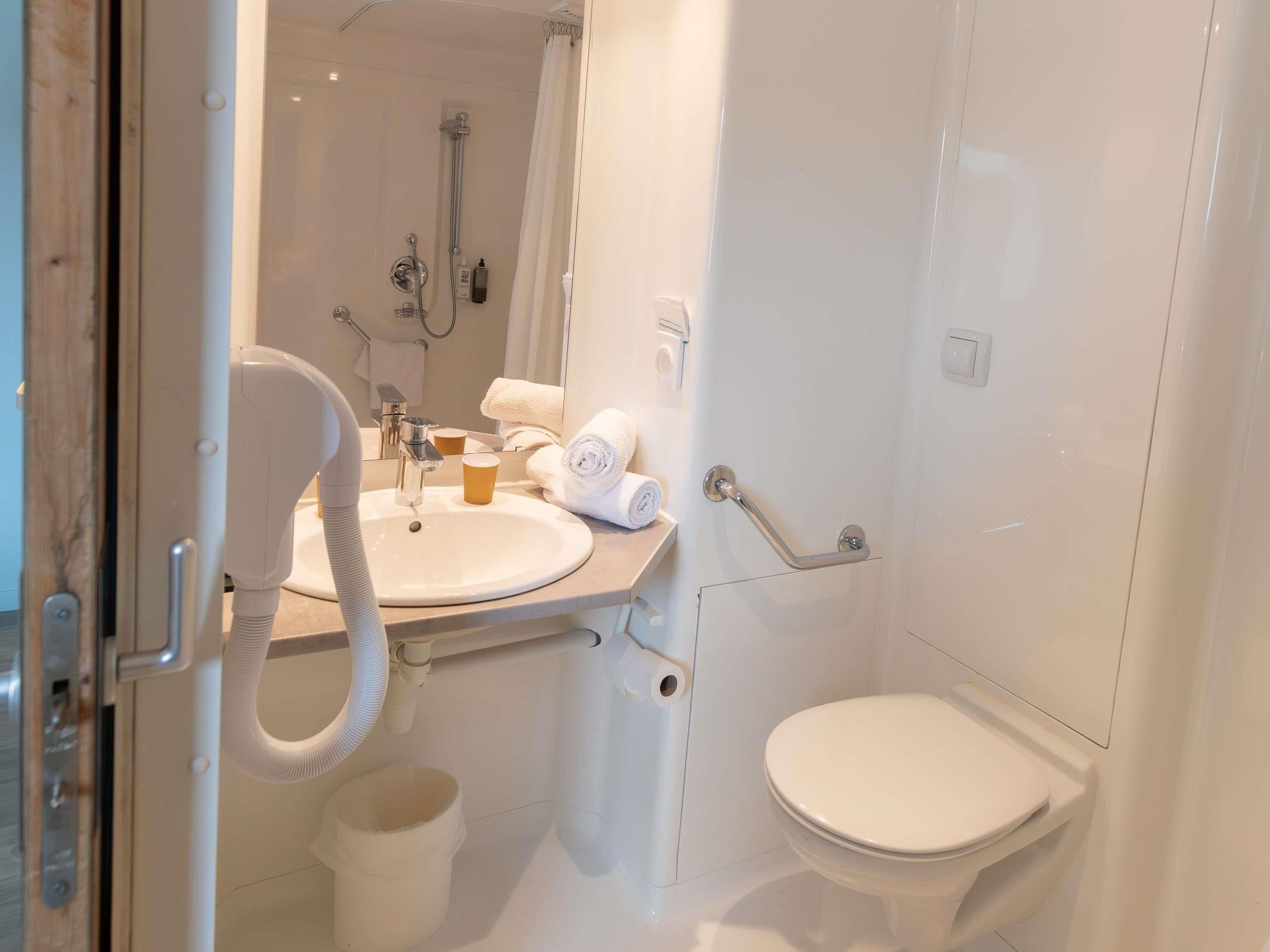 A bathroom with a sink, toilet, and shower.