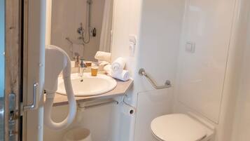 A bathroom with a sink, toilet, and shower.