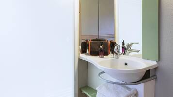 A bathroom with a white sink, a mirror, and a towel rack.