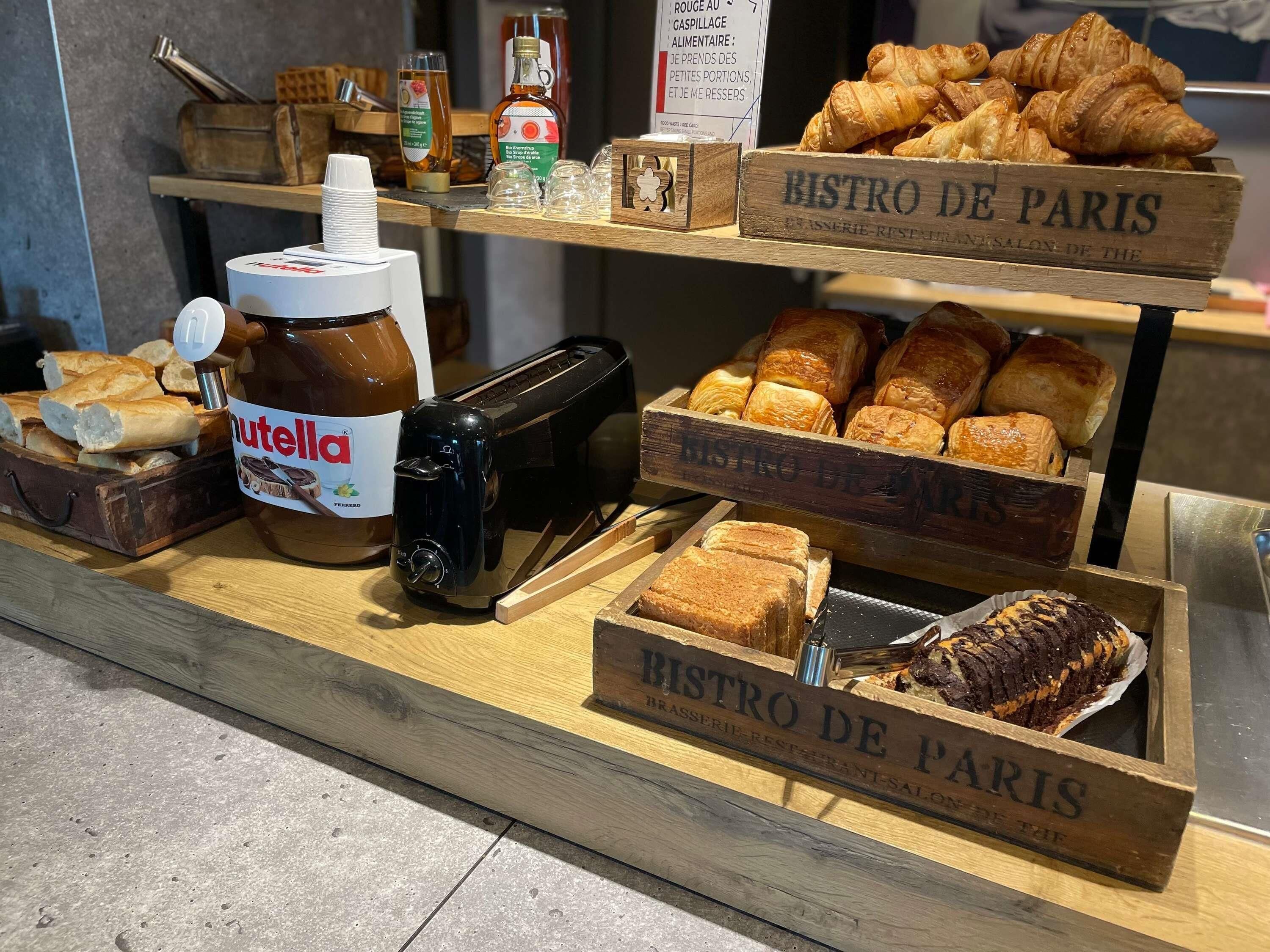 Een bakkerijvitrine met Nutella, croissants en brood.