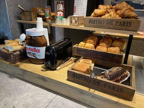Une vitrine de boulangerie présentant du Nutella, des croissants et du pain.