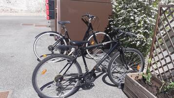 Una bicicleta aparcada al costat d'una tanca de fusta amb una jardiniera amb plantes.
