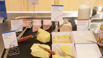 A breakfast buffet with various food items and utensils.