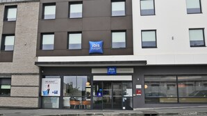 Un edificio moderno con un letrero que indica 'ibis budget', un hotel económico.