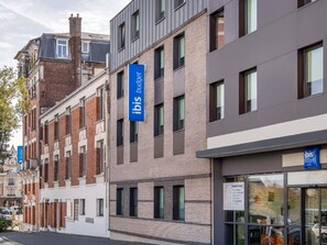 A modern hotel building with a prominent 'ibis budget' sign, multiple windows, and a visible entrance. - ibis budget Saint-Quentin Centre Gare (Saint-Quentin)