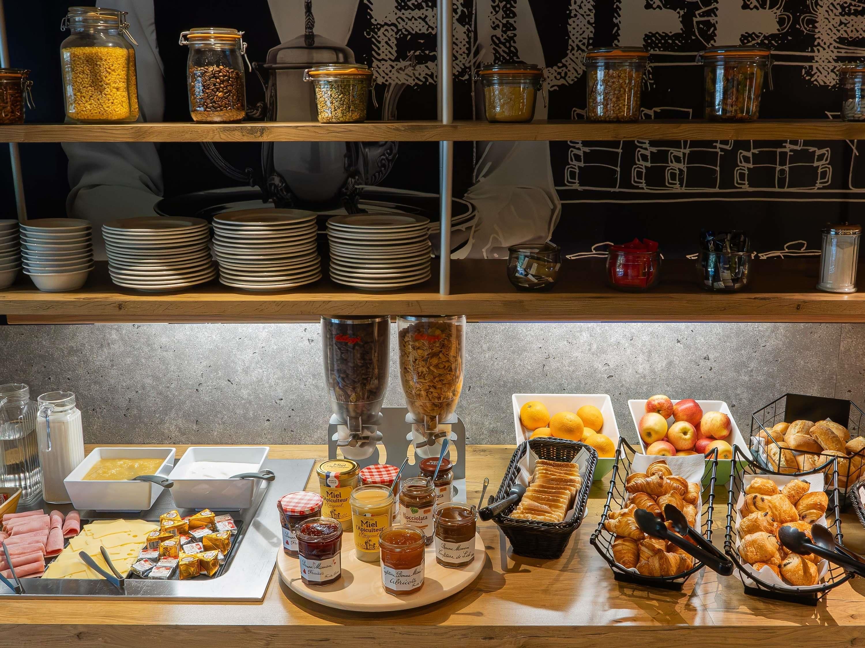 A buffet setup with various food items and condiments.