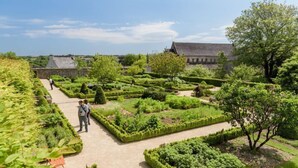 A garden with neatly trimmed hedges and a pathway. - ibis budget Caen Centre Gare (Caen)