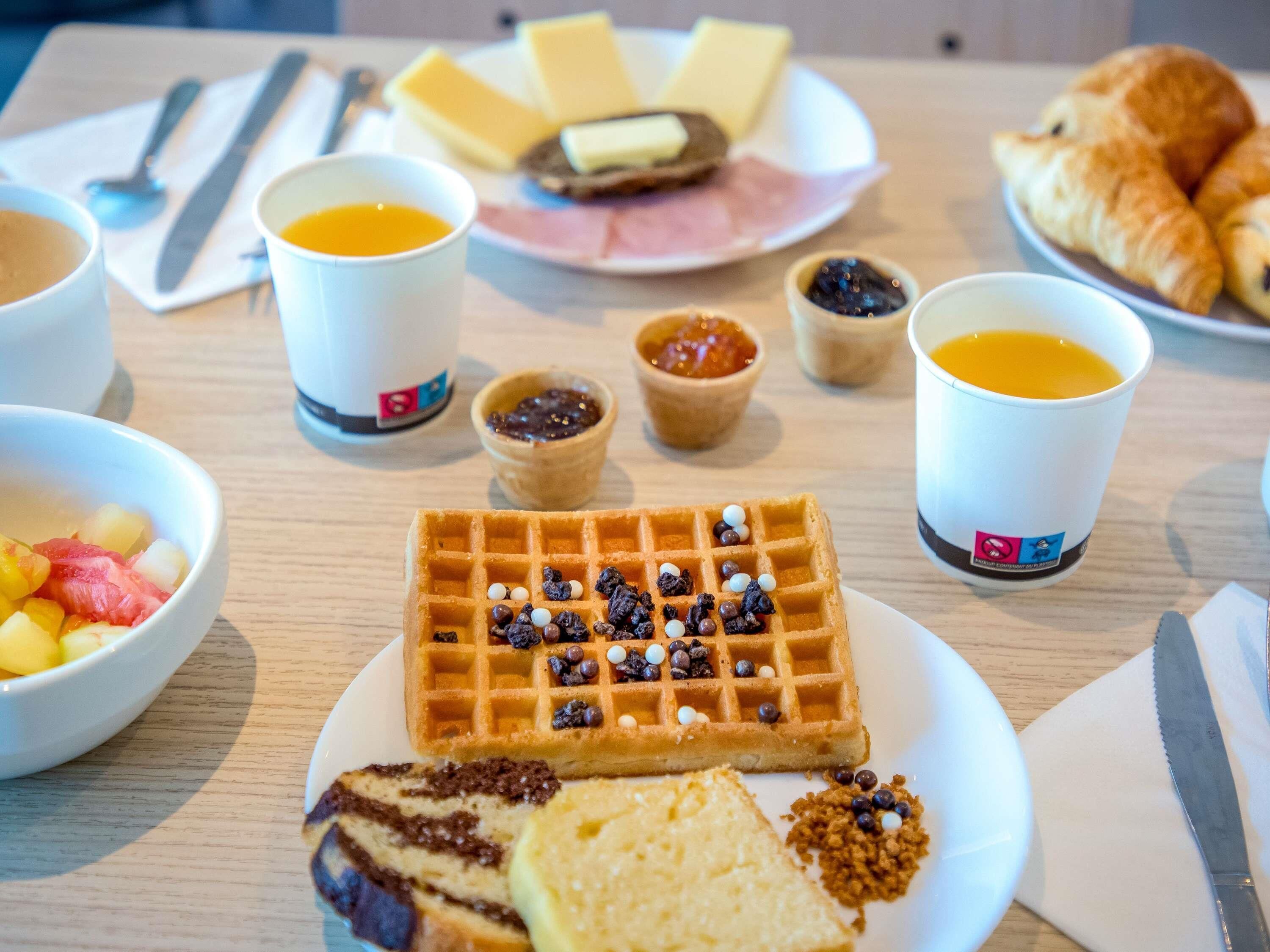 Un desayuno con gofres, pasteles y diferentes acompañamientos.