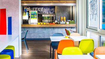A modern cafe interior with a bar area, seating, and a view through a window.