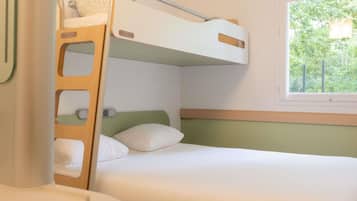 Una cama litera con escalera, una mesita de noche y una ventana con vista a árboles.