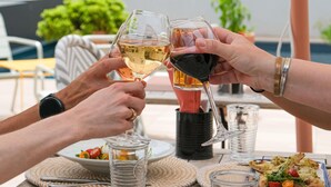 A wooden table with a glass of white wine, a glass of red wine, and a plate of food. - ibis budget Montauban Les Chaumes (Montauban)
