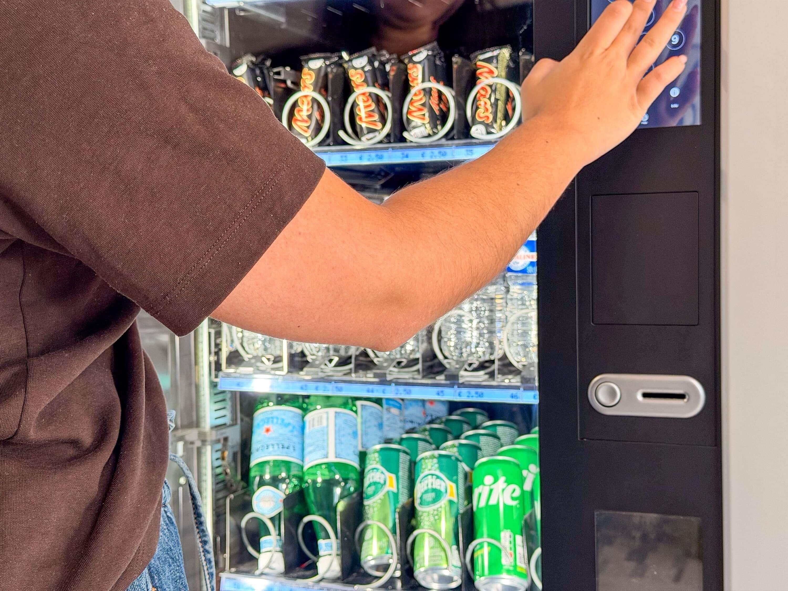 Ein Getränkeautomat mit verschiedenen Getränken, darunter Dosen und Flaschen.