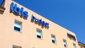 A building with 'ibis budget' and 'HOTEL' signs.