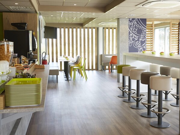 A modern cafe with a long counter, multiple chairs, and stools.