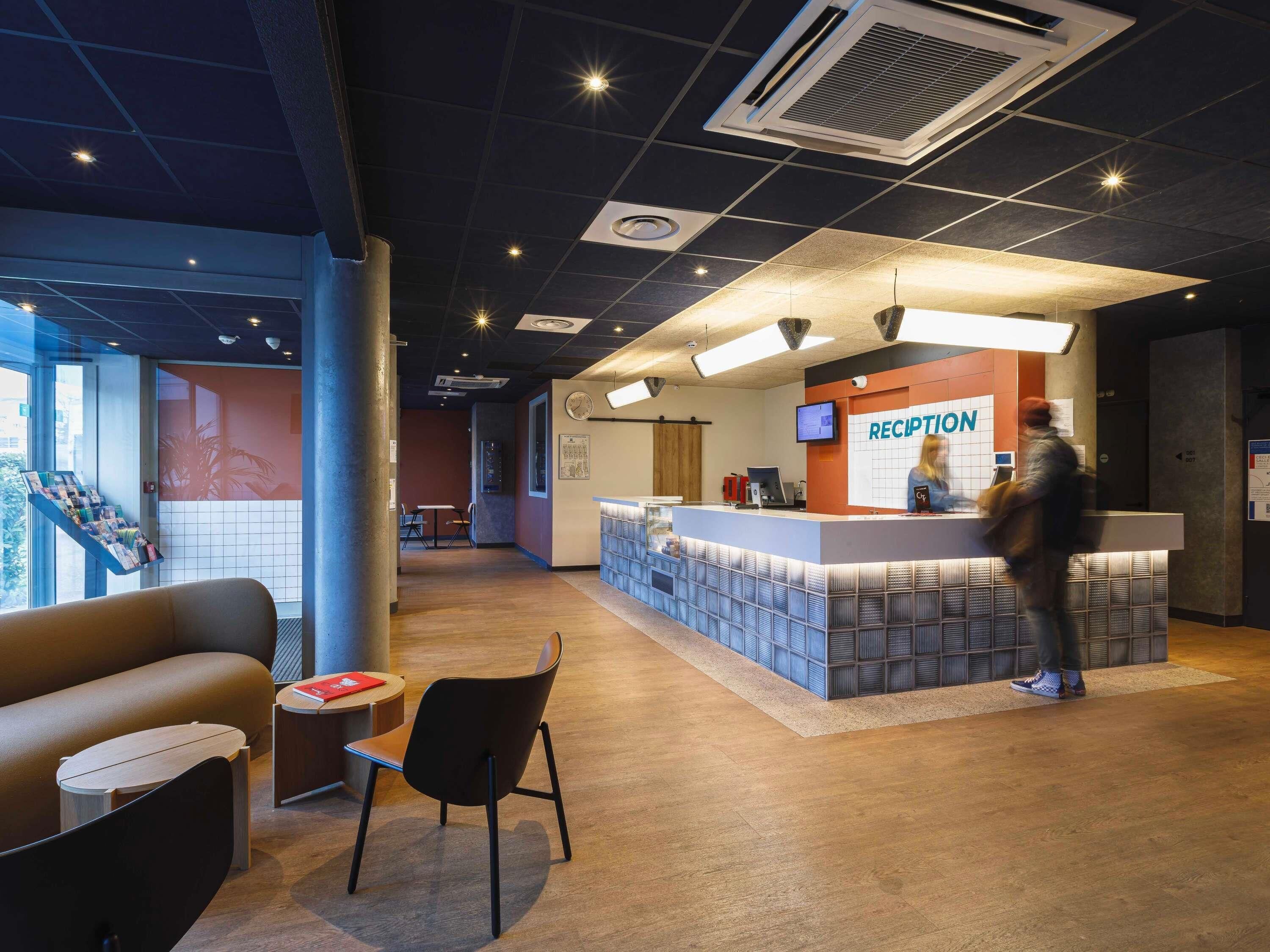 A reception area with a counter, chairs, and a large window.