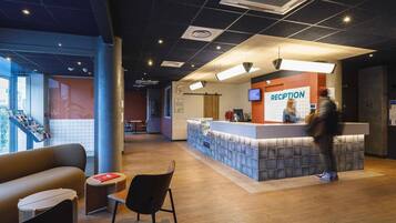 A reception area with a counter, chairs, and a large window.