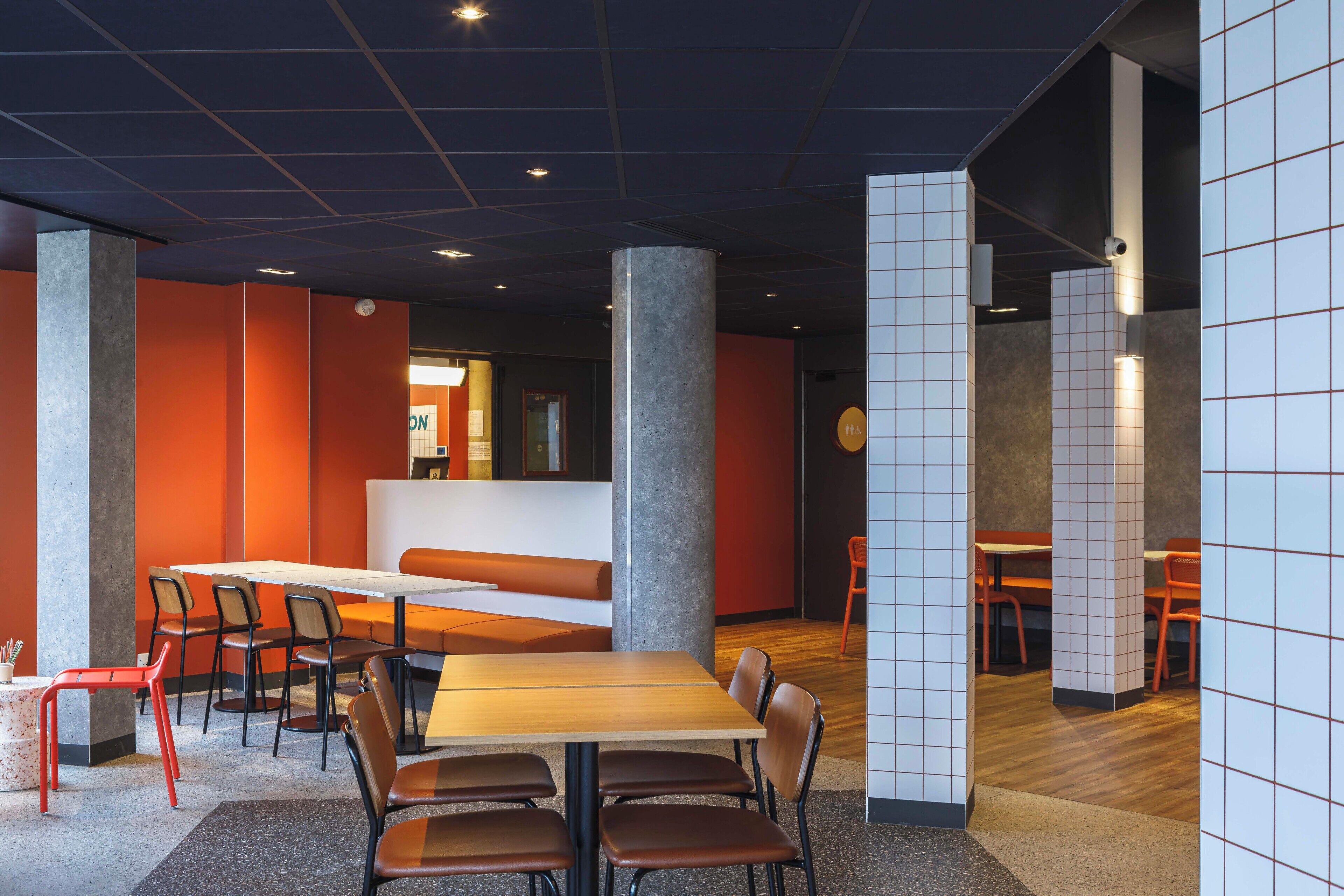 Un intérieur moderne avec un espace salon central, de hauts plafonds et une variété d’agencements de sièges.